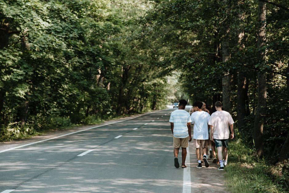 Teenagers Walking on Roadside in Forest